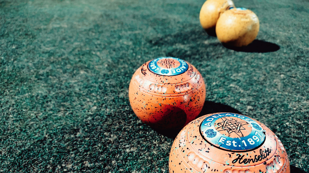 Well loved bowling balls on grass pitch