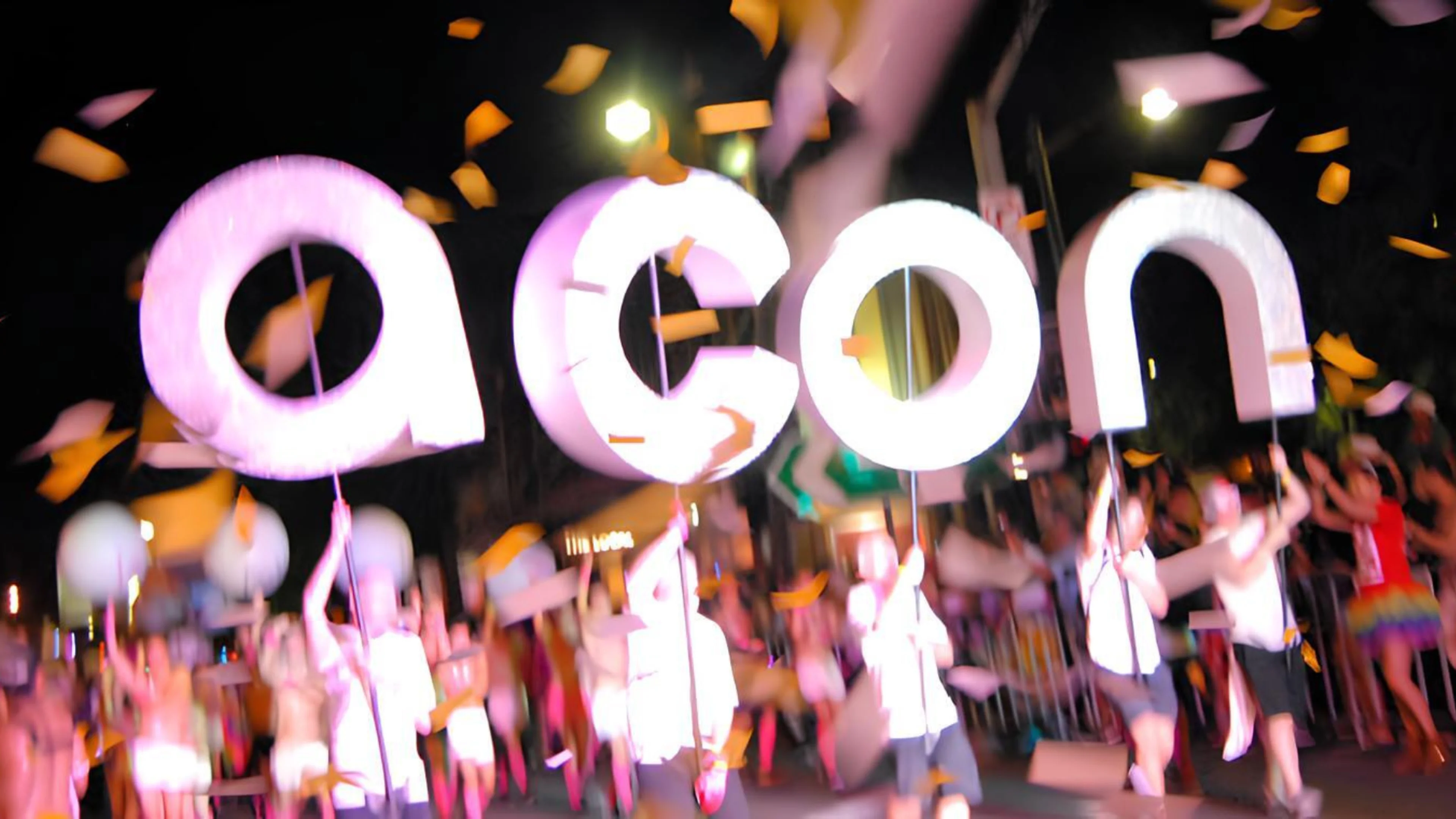 ACON letters held in air by crowd at parade at night