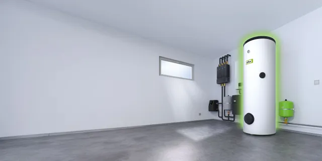 Minimalist room with a green glowing Storatherm Aqua+Heat hot water storage tank. HVAC system in the corner, and two narrow windows on the white walls.