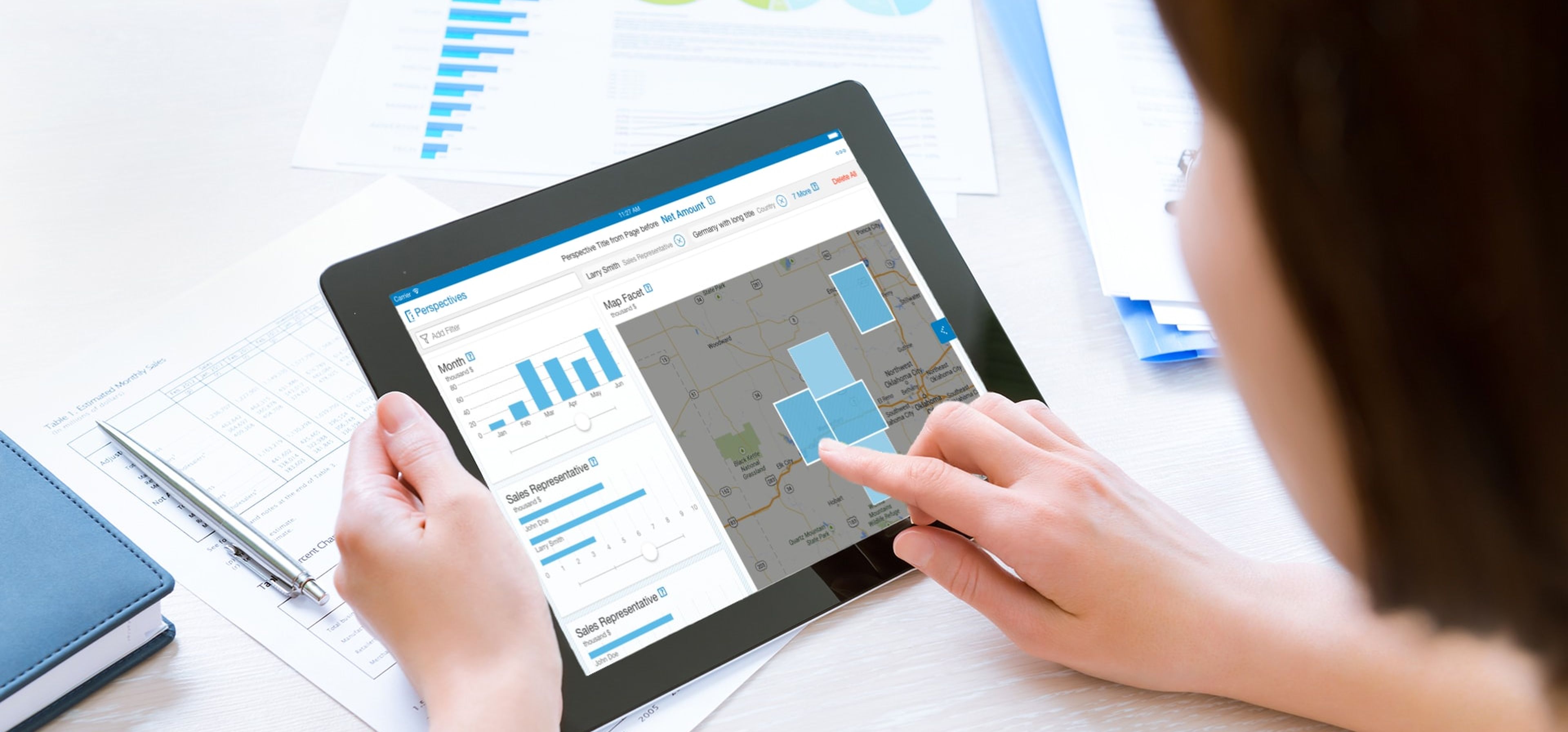 Tablet mit SAP Hana auf einem Tisch mit ausgedruckten Charts.