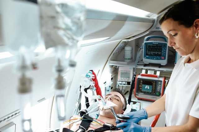 Frau im Krankwagen untersucht einen Patienten