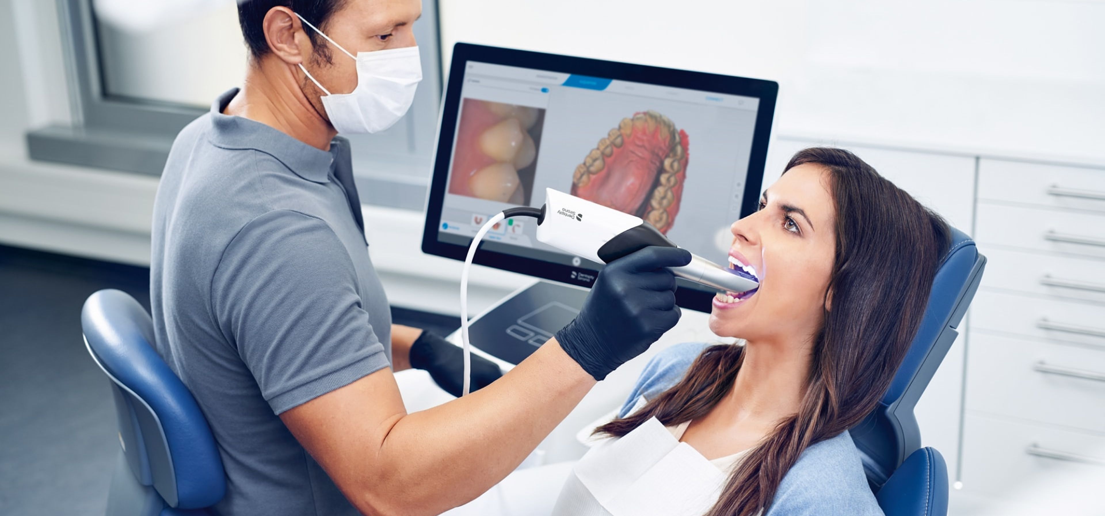 Zahnarzt setzt CEREC-System bei Patientin ein.
