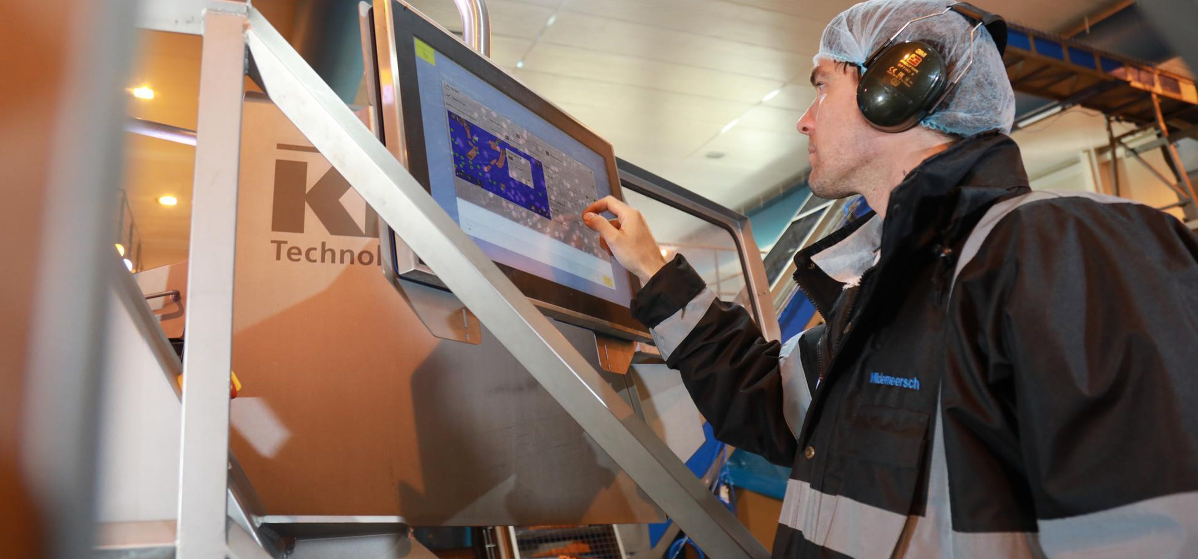 Mann bedient User Interface der Lebensmittel-Sortiermaschine COMPASS