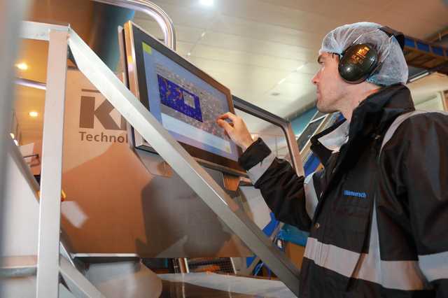 Mann bedient User Interface der Lebensmittel-Sortiermaschine COMPASS
