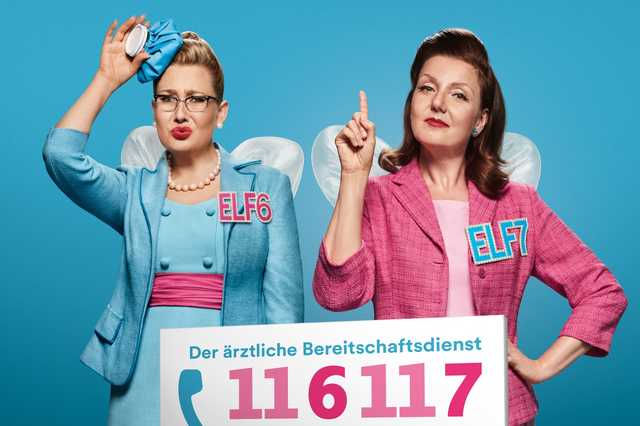 Zwei Frauen als Feen verkleidet: ein streckt den Zeigefinder, die andere hält sich einen Eisbeutel an den Kopf. Darunter die Telefonnummer 116117.