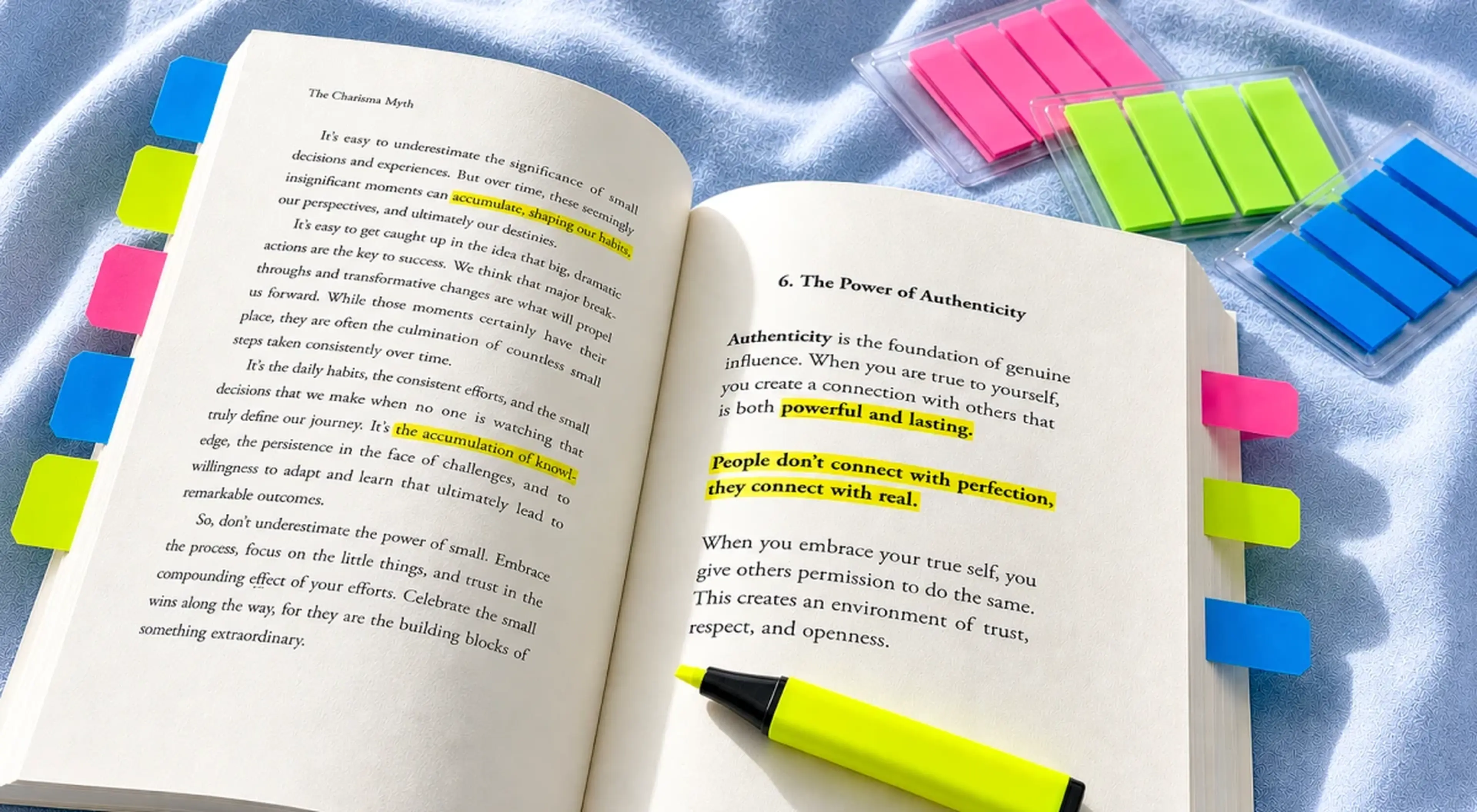 Open book with colorful sticky note tabs and yellow highlighter on a blue surface, showing highlighted text with a user profile icon overlay