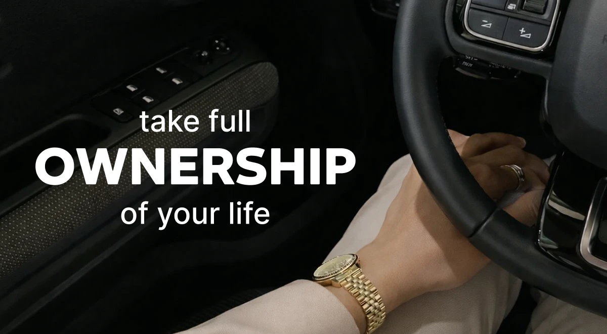 _Woman with a gold watch gripping a car steering wheel in a dark interior, representing a girlboss mindset of taking ownership and self-growth as a woman CEO