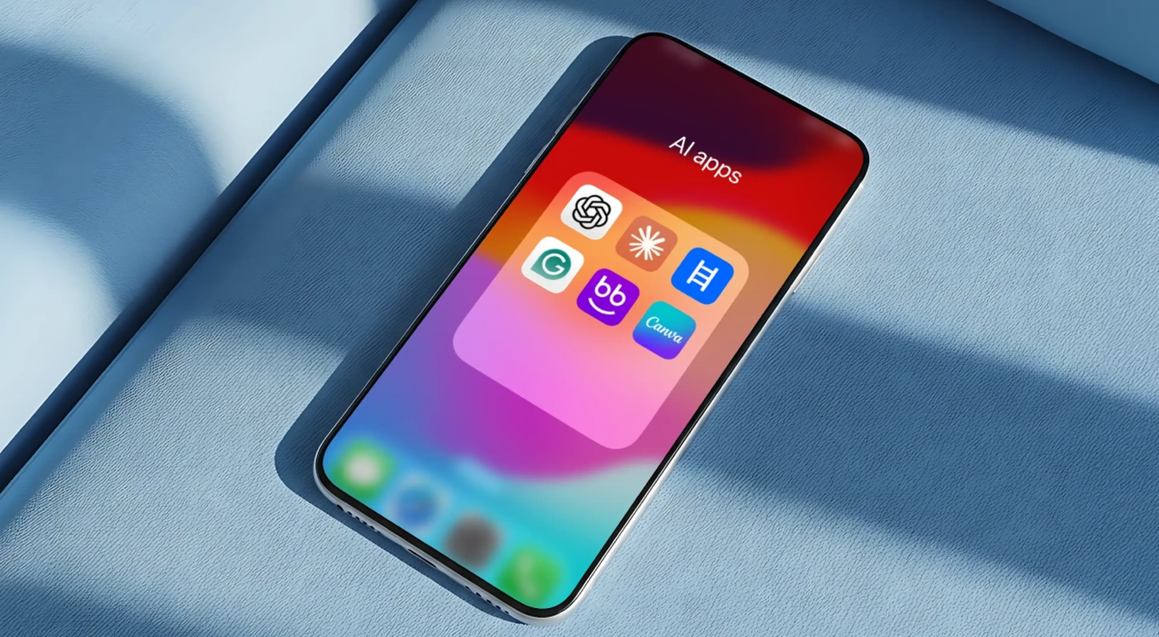 iPhone on a blue fabric surface displaying a folder of AI apps including ChatGPT and Canva icons on a colorful home screen