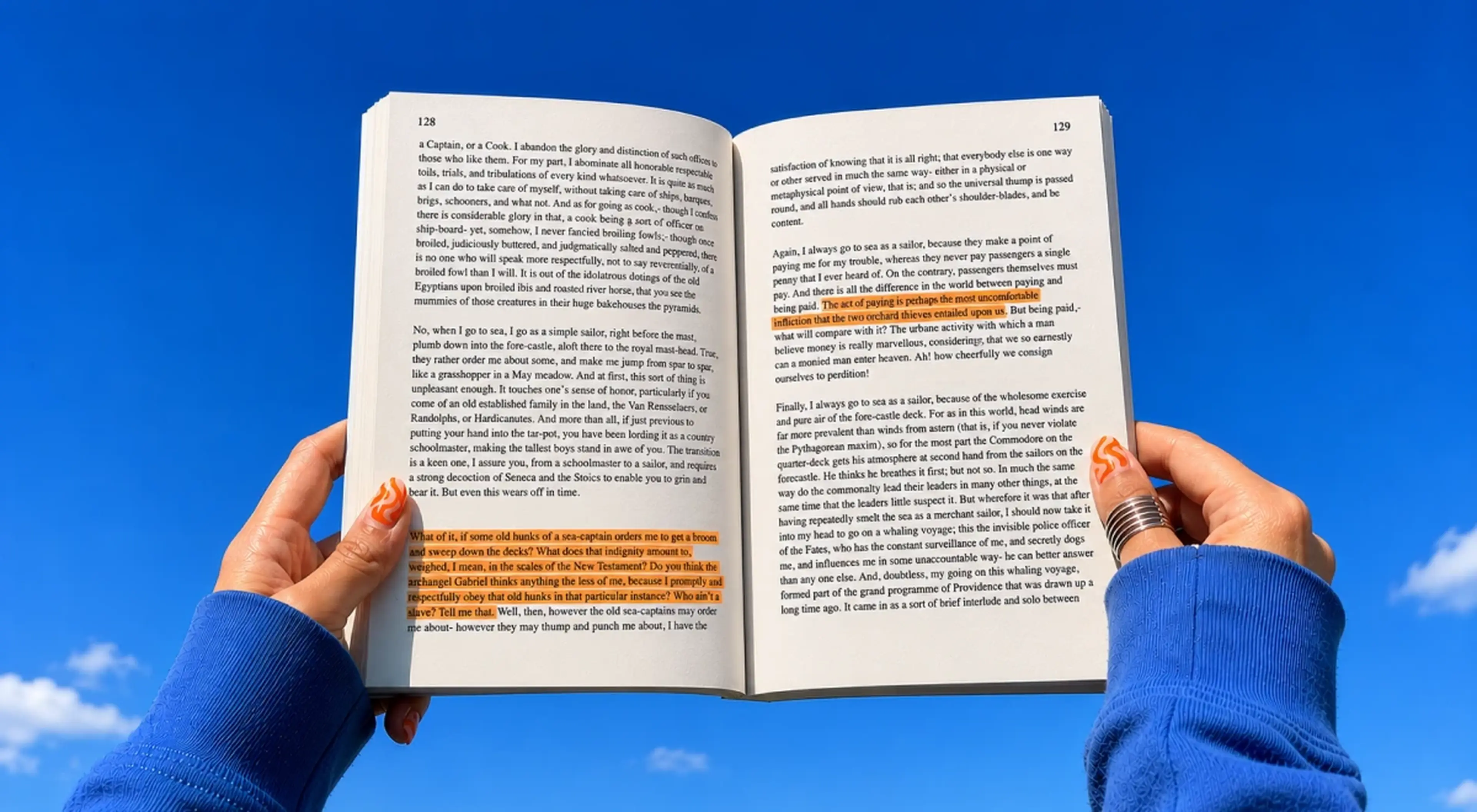 Person in a blue sweater holding open a highlighted paperback book against a bright blue sky with clouds, representing literature reading and book trivia