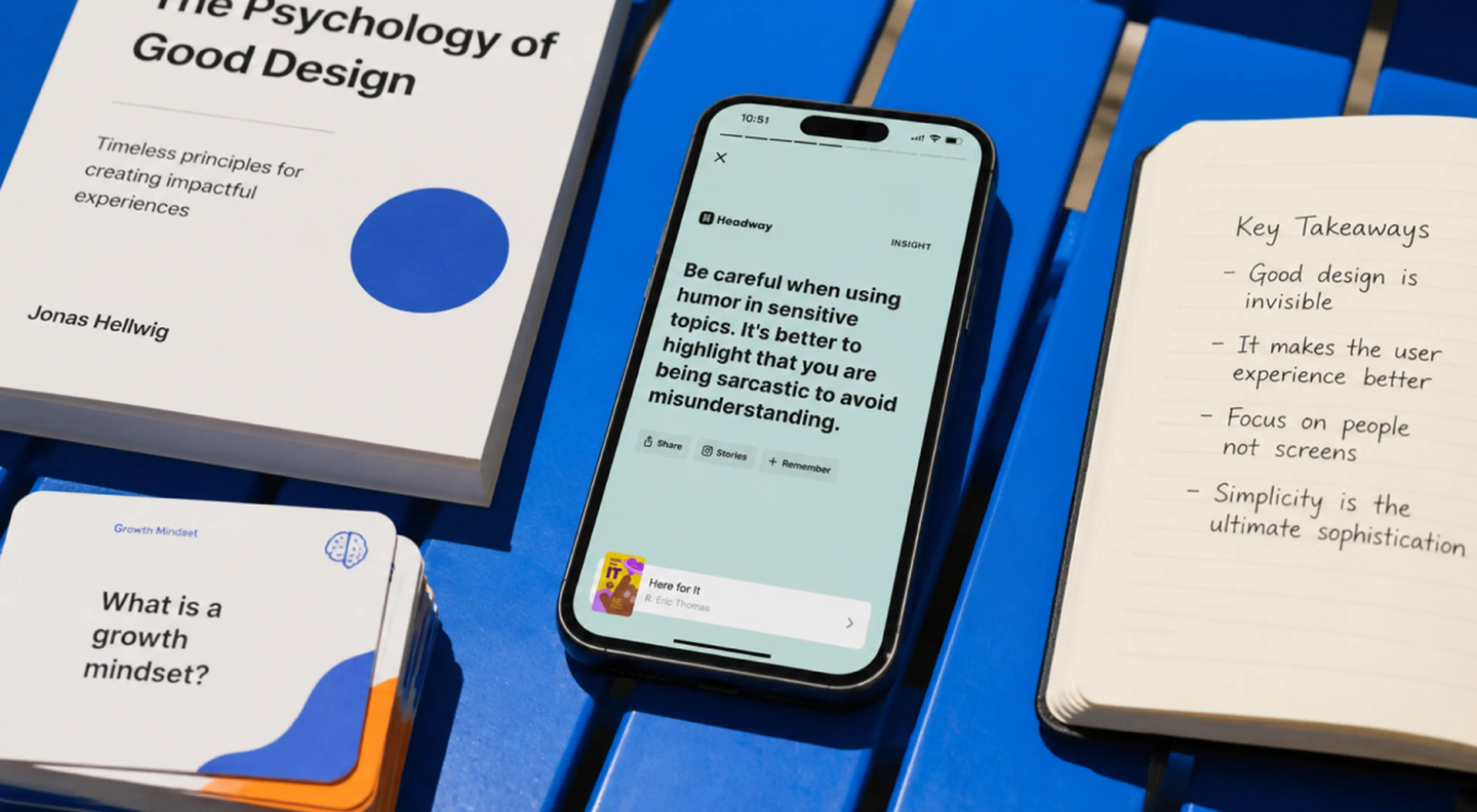 Smartphone showing Headway app insight on a blue table beside design books and notebook, illustrating microlearning vs s