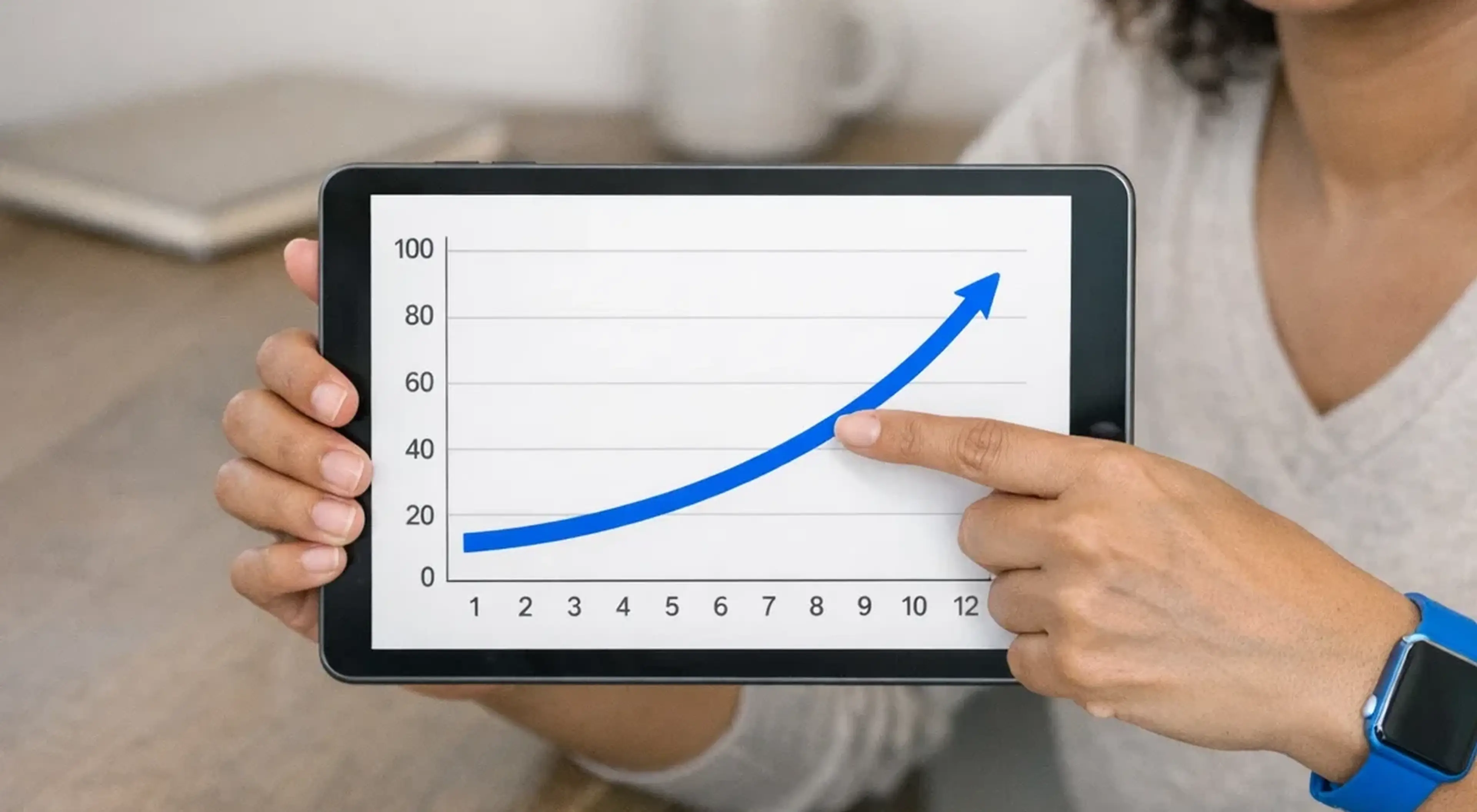 Woman pointing at upward blue arrow chart on tablet, wearing smartwatch, illustrating self-improvement technique and personal growth progress over time