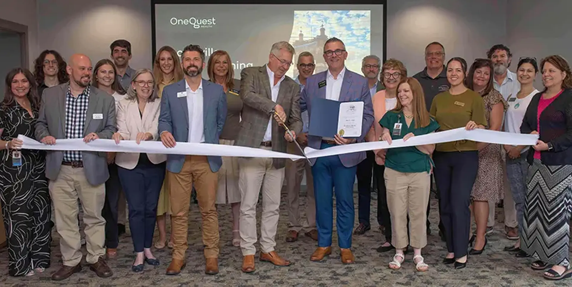 A group photo of the ribbon cutting ceremony at the Louisville Outpatient Center Grand Opening event.