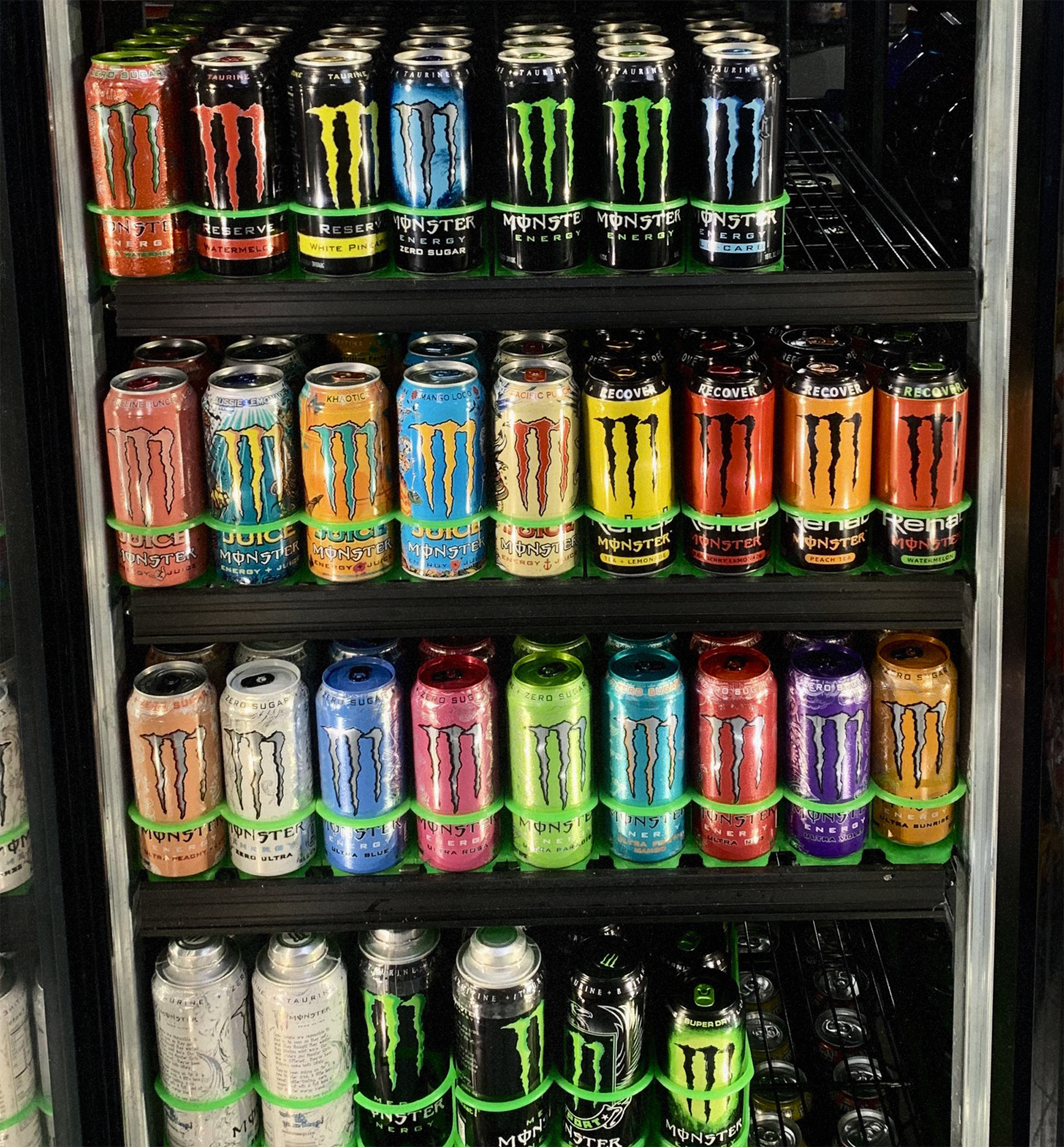 Monster beverages lined up in a gas station fridge