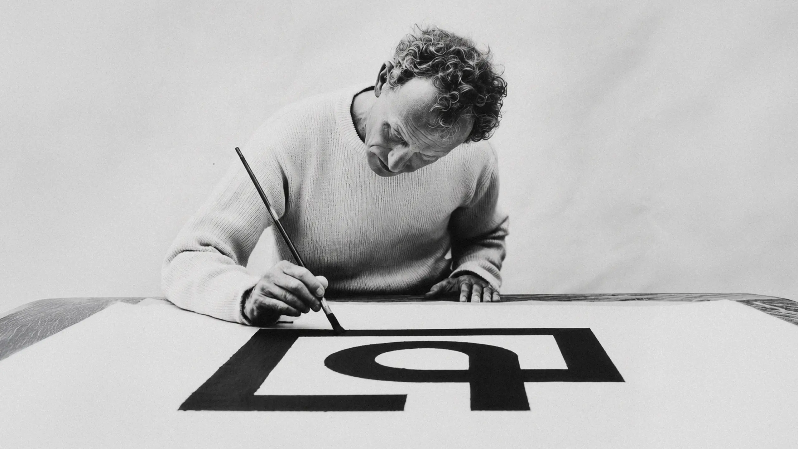 Designer painting the Quartr logomark