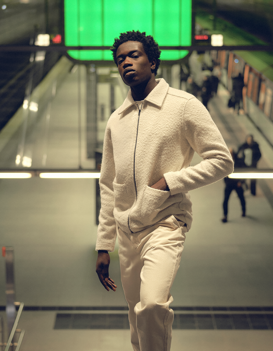 Man gekleed in een wit overshirt en een beige broek