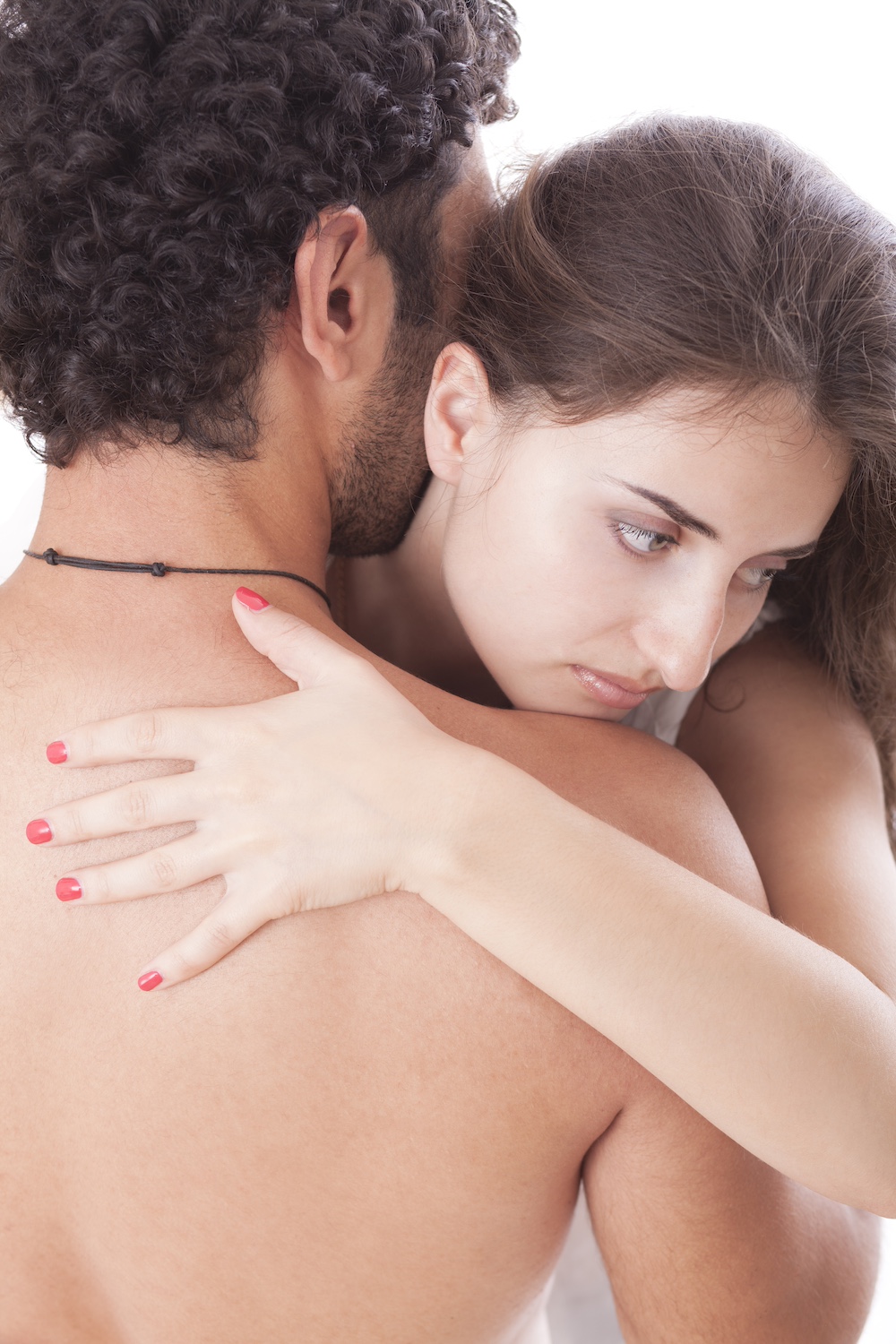 Paar liegt eng umschlungen im Bett in einem intimen Moment