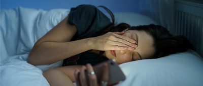 Frau liegt wach im Bett.