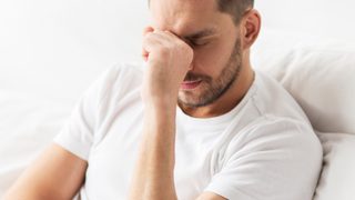 Mann erschöpft und müde im Bett.