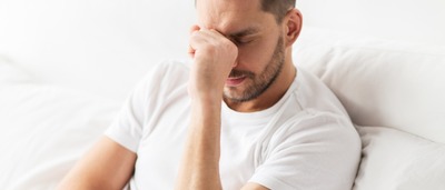 Mann erschöpft und müde im Bett.