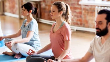 Menschen meditieren im Yogaraum – Entspannung zur Unterstützung des Kreislaufsystems