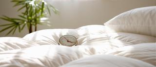 Wecker, der auf Bettdecke liegt.