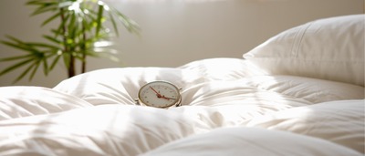 Wecker, der auf Bettdecke liegt.