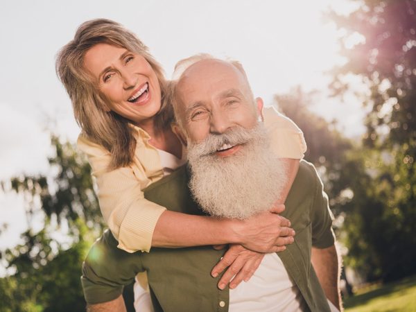 Ältere Mann trägt ältere Frau Huckepack in der freien Natur