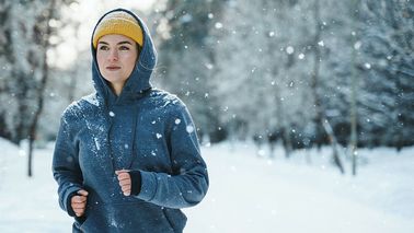 Frau joggt im Winter zur Stärkung des Immunsystems gegen Erkältung.