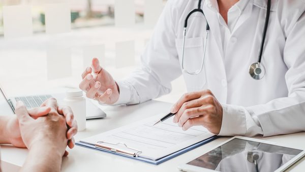 Arzt füllt mit Patienten einen Diagnosebogen aus