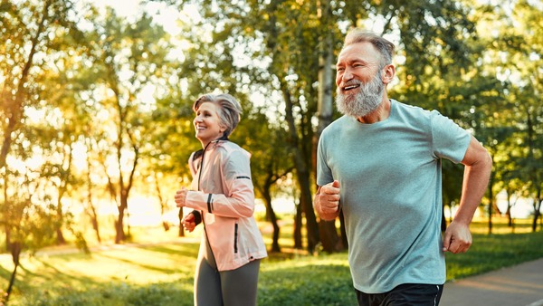 Älteres Paar geht bei schöner Abendstimmung joggen
