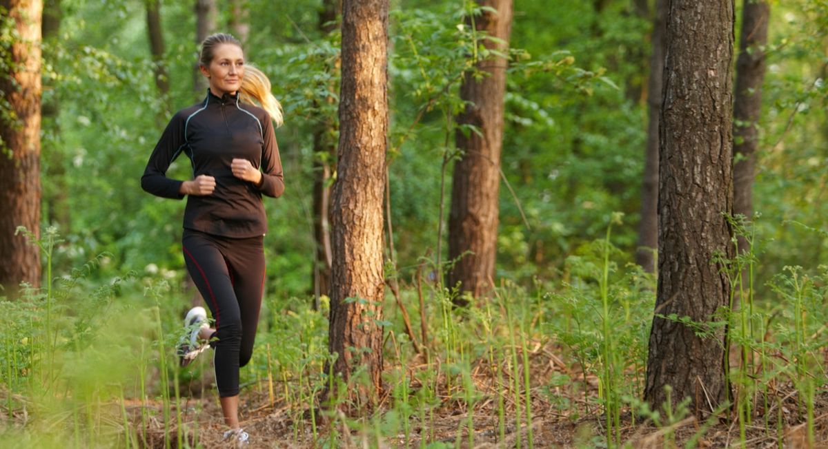 Frau, die im Wald joggt.