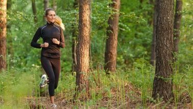 Frau, die im Wald joggt.