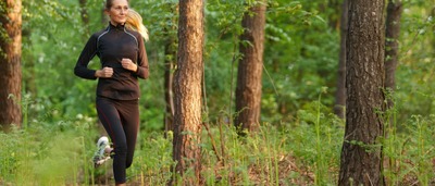 Frau, die im Wald joggt.