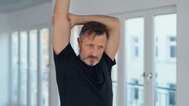 Mann macht Dehnübungen.