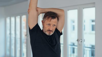 Mann dehnt sich im Stehen – ruhige Alltagsbewegung bei Rheuma.