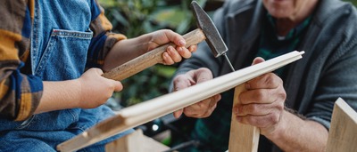 Großvater und Enkel bauen ein Vogelhaus.