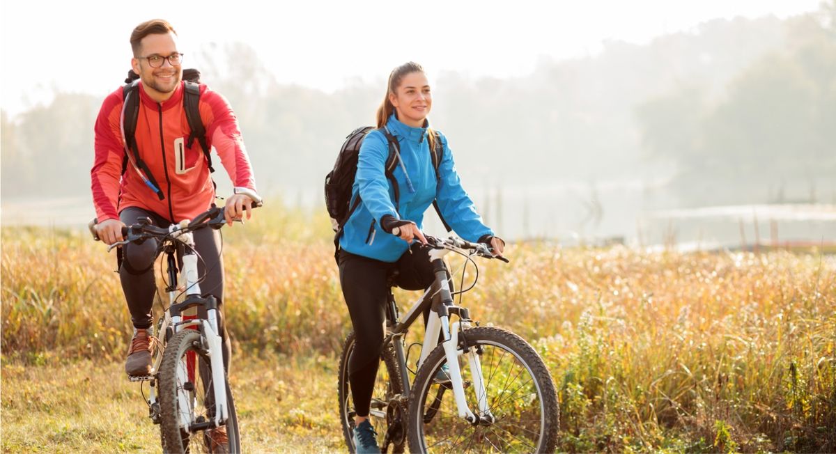 Zwei Personen auf dem Fahrrad in der Natur.