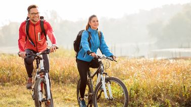 Zwei Personen auf dem Fahrrad in der Natur.