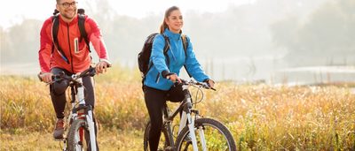 Zwei Personen auf dem Fahrrad in der Natur.