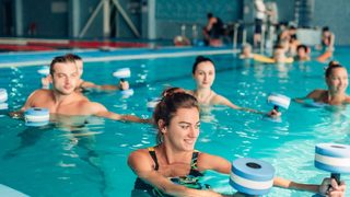 Sportgruppe beim gelenkschonenden Wassergymnastik-Training mit Aqua-Hanteln