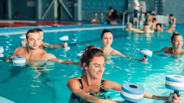 Sportgruppe beim gelenkschonenden Wassergymnastik-Training mit Aqua-Hanteln