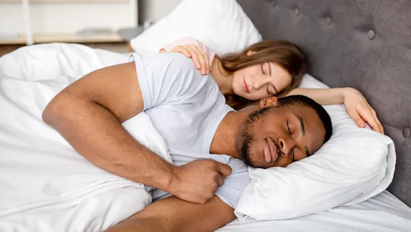 Paar liegt im Bett und schläft.