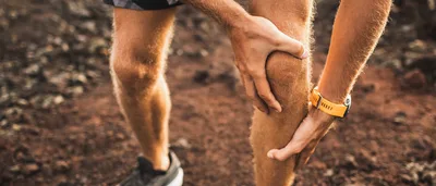 Symbolbild: Mann hält beim Laufen sein schmerzendes Knie – Hinweis auf Rheuma und Gelenkschmerzen.