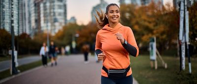 Frau joggt entspannt im Stadtpark – moderates Lauftraining unterstützt die natürliche Sehnen Regeneration.