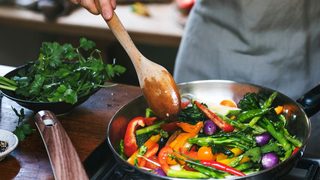 Person rührt eine bunte Gemüsepfanne – Symbolbild für eisenreiche Ernährung und Vitamin-C.
