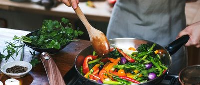 Person rührt eine bunte Gemüsepfanne – Symbolbild für eisenreiche Ernährung und Vitamin-C.