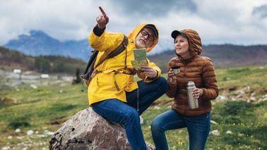 Zwei Menschen mit wetterfester Kleidung beim Wandern – Bewegung als Schutz bei Gelenkbeschwerden durch Wetterwechsel.