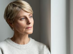 Frau wirkt nachdenklich und zeigt Anzeichen eines psychisch bedingten beklemmenden Gefühls