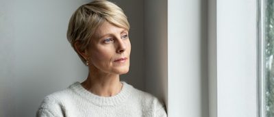 Frau wirkt nachdenklich und zeigt Anzeichen eines psychisch bedingten beklemmenden Gefühls