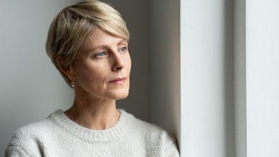 Frau wirkt nachdenklich und zeigt Anzeichen eines psychisch bedingten beklemmenden Gefühls